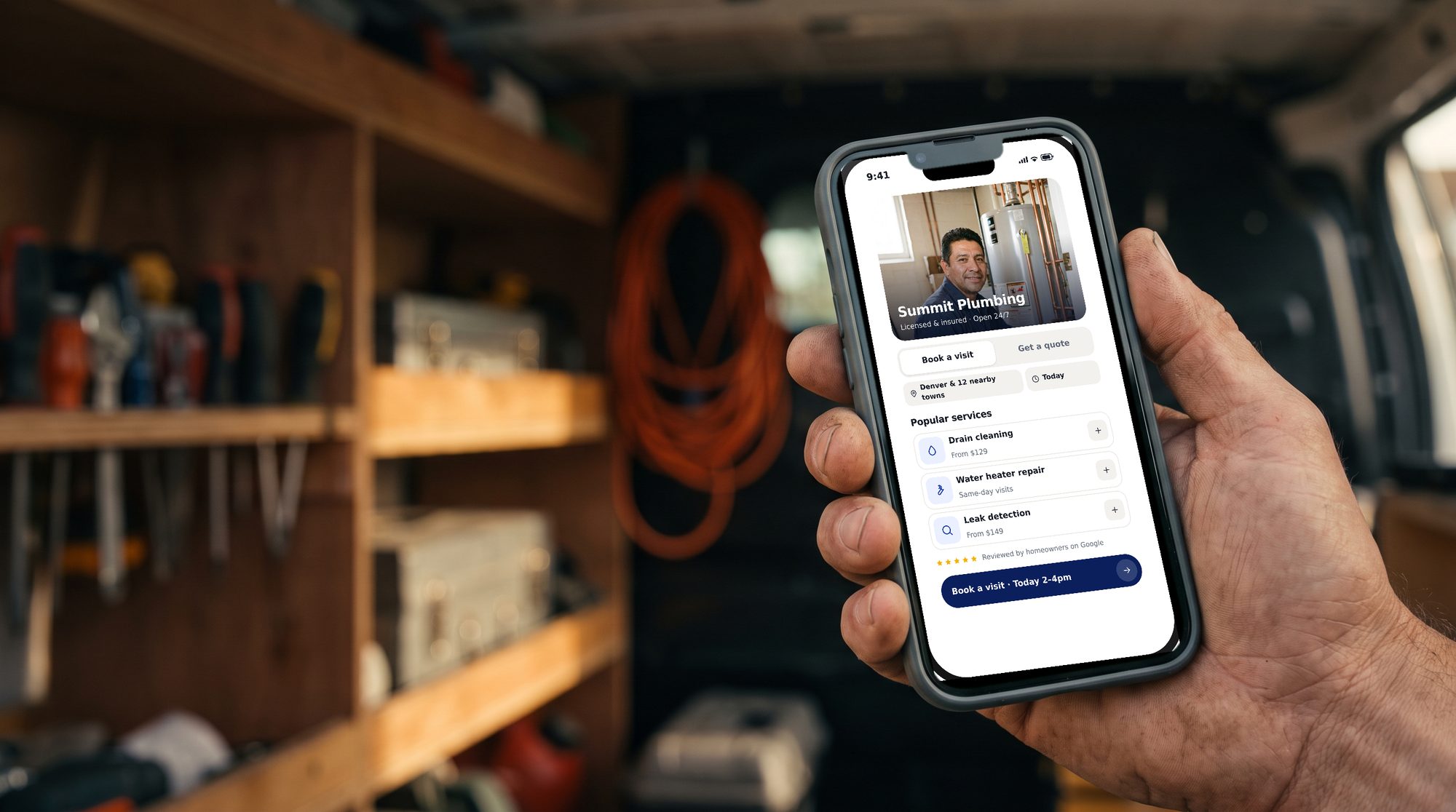 A tradesperson holding a phone showing a Zome-powered booking site (illustrative)